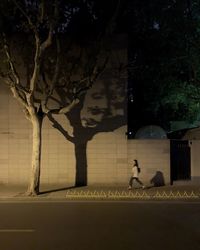 Blurred motion of woman walking on sidewalk at night