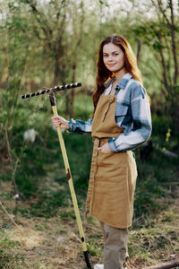 Portrait of farmer holding rake at farm