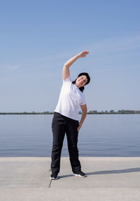 Full length of man standing in sea against sky