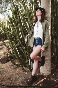 Full length of woman standing against plants