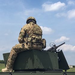 Low angle view of soldier sitting on a tank