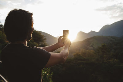 Man talking selfie while standing against mountains