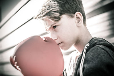 Boy wearing boxing glove while standing outdoors