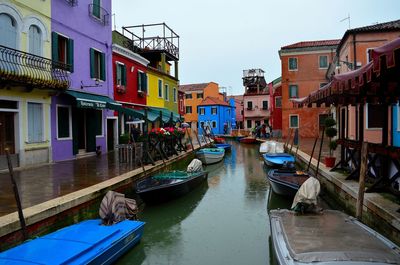 Boats moored on canal in city