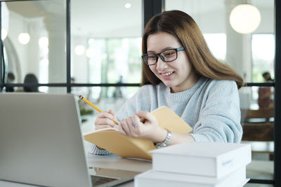 Portrait of smiling woman sitting on table