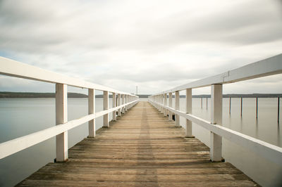 Wooden pier over lake against sky