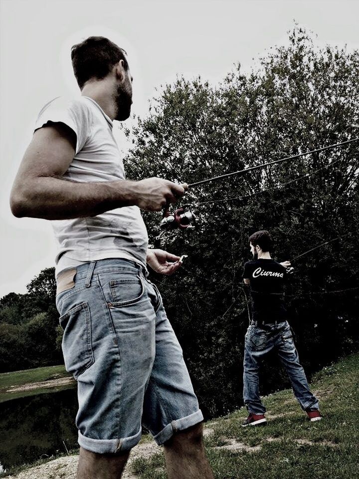 lifestyles, casual clothing, leisure activity, full length, standing, young adult, person, three quarter length, young men, togetherness, field, grass, bonding, rear view, tree, men, side view
