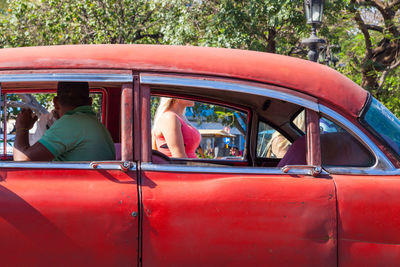 Man sitting in car while looking at woman