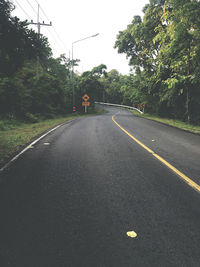 Road by trees against sky