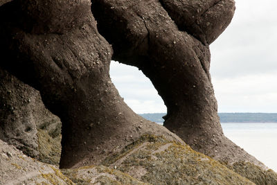 Rock formation in sea against sky