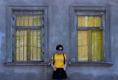 Portrait of man standing against yellow wall