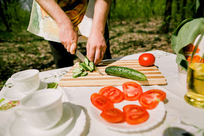 Close-up of man cutting vegetables on cutting board