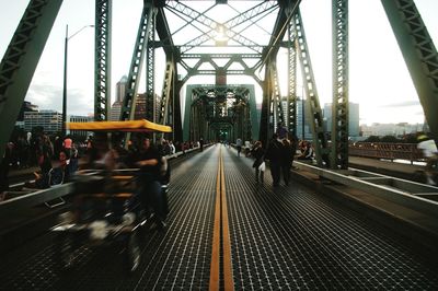 People and vehicle at hawthorne bridge against sky