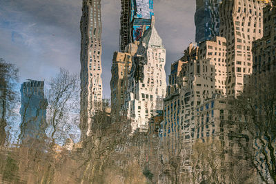 Reflection of buildings in city on water in a park