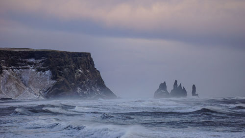 Rock formation in sea against sky