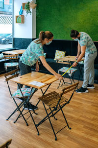 Workers wearing masks while cleaning cafe