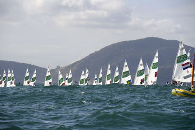 People on boat in sea against sky