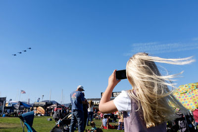 Woman standing against blue sky