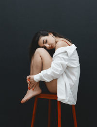 Woman looking away against black background