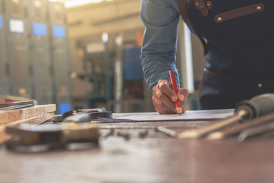 Midsection of carpenter working in workshop