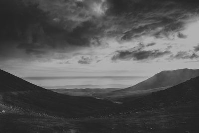 Scenic view of mountains against cloudy sky