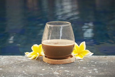 Glass of coffee latte on beautiful swimming pool.