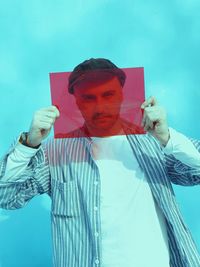 Portrait of young man holding umbrella