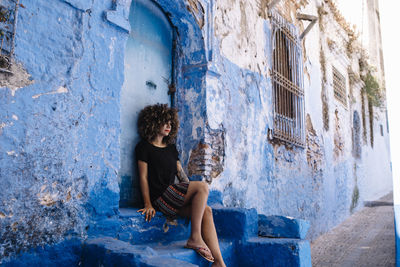 Beautiful woman sitting outside building