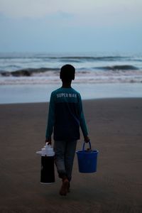 Rear view of man standing on beach