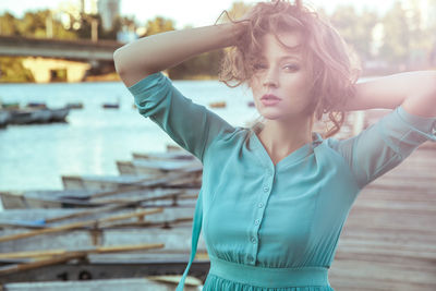 Portrait of beautiful woman standing against water