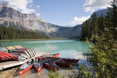 Boats moored in lake against mountains