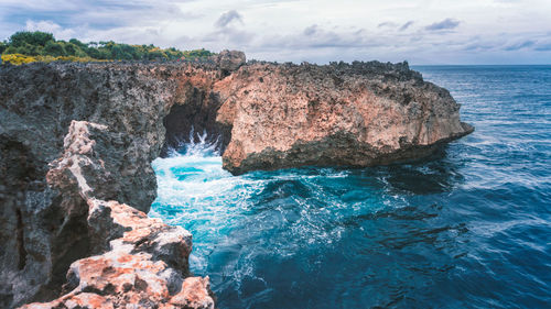 Rock formations in sea against sky