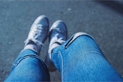 Low section of woman wearing torn jeans