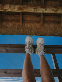 Low section of woman standing against blue wall