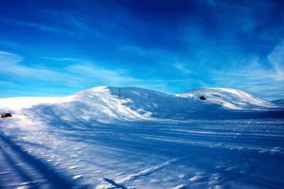 Scenic view of snowcapped mountains against blue sky