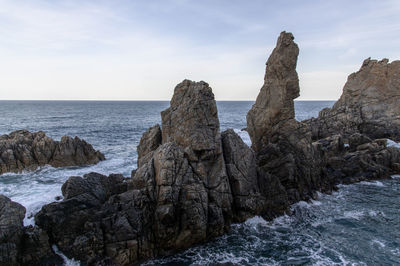 Panoramic view of rocks on beach against sky