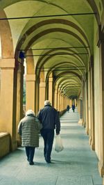 Rear view of people walking in corridor of building