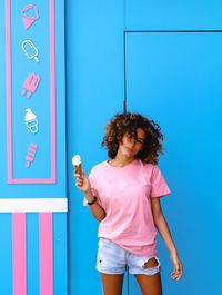 Rear view of girl standing against wall