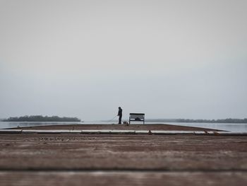 Man standing on beach against clear sky