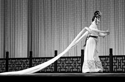 Woman in costume performing dance on stage