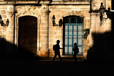 People walking on street against building