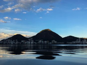 Scenic view of lake and mountains against blue sky