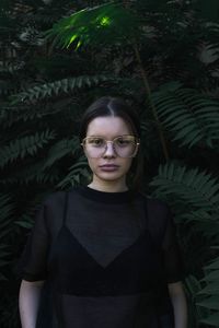 Portrait of woman standing against plants