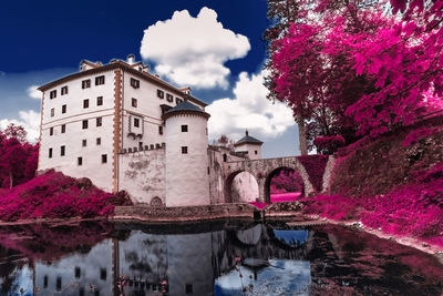 Bridge over river amidst buildings against sky