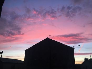 Low angle view of silhouette building against sky during sunset