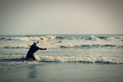 Man standing in sea against clear sky