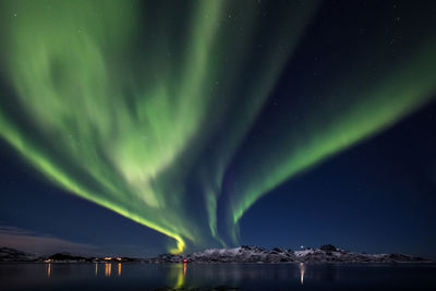 Scenic view of lake against sky at night during winter