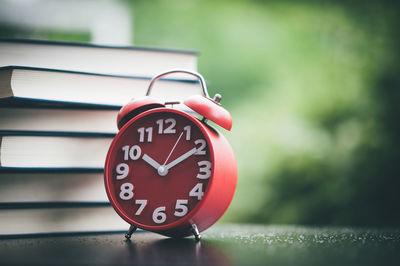 Close-up of alarm clock and books on table