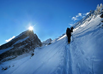 People skiing on snowcapped mountain against sky