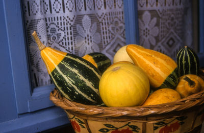 Close-up of squash vegetables in wicker basket at home